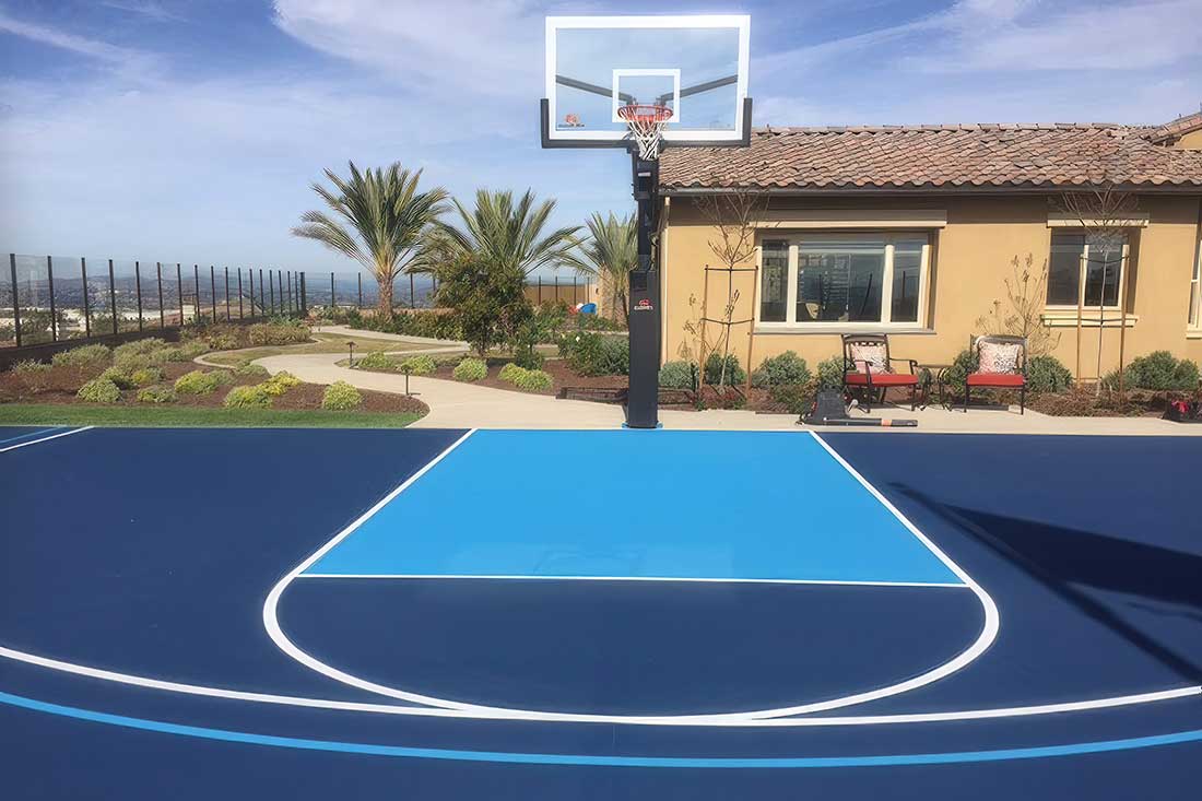 the photo shows a residential basketball court in some beautiful two-tone blue colors with white striping.