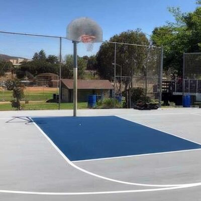 the photo shows the blue and dove gray basketball court with white striping built for the San Carlos Recreation Center by Ferandell Tennis Courts.