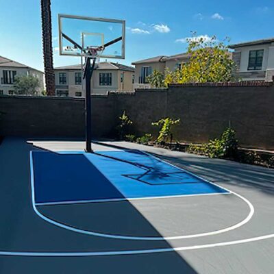 the photo shows a basketball net and key painted in a blue and grey color combo with white striping on the side of a residence in Irvine.