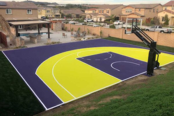The Photo Shows A Residential Basketball Half Court Painted In Lakers Colors Of Tournament Purple And Yellow With White Striping.