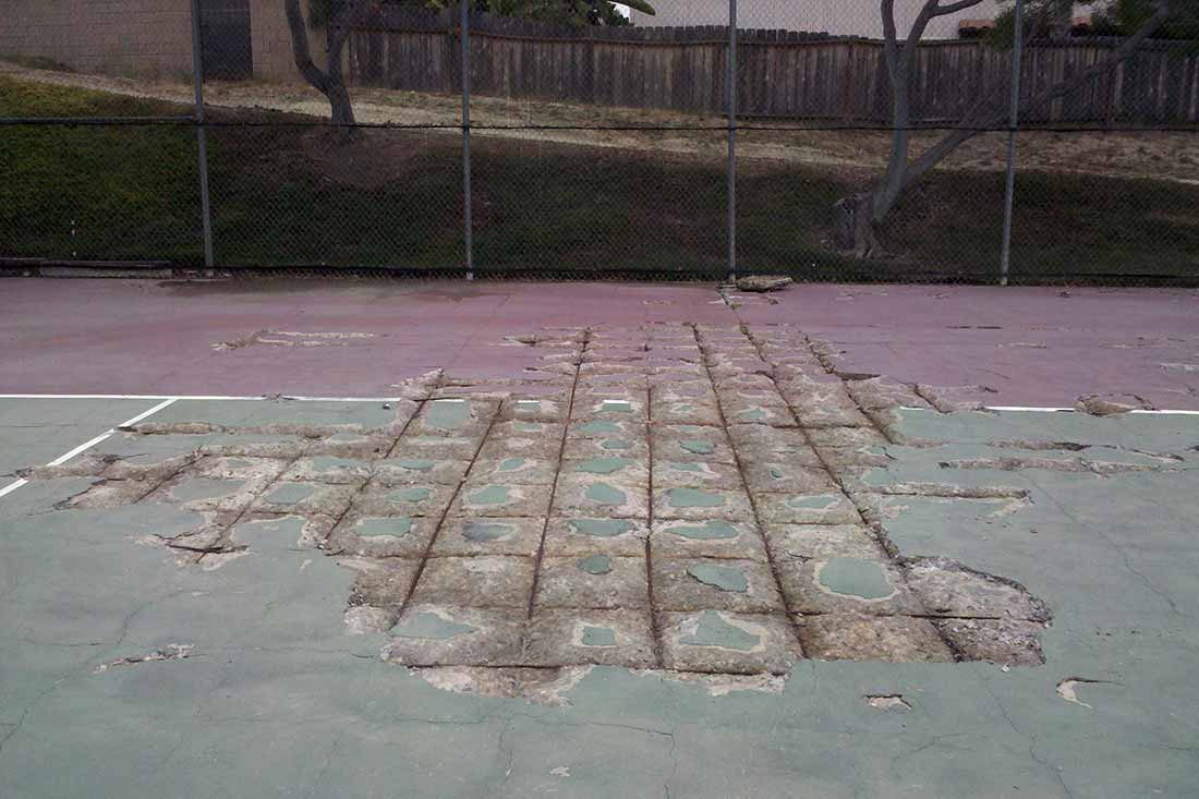 photo shows an outdoor game court with cracks