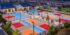 photo shows an aerial view of Canvas Park Community in Ontario California with four colorfully painted pickleball courts and two basketball courts using bright red, ice blue, and a fusion of yellow and orange, with white striping. Aerial photography provided by Frohlich Photography at CMFPhoto.com.