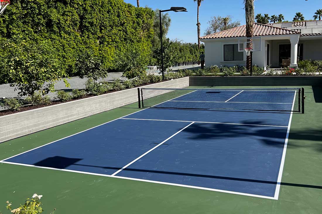 photo shows a beautiful blue pickleball court with green surround constructed in La Quinta at a private residence
