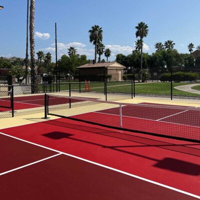 The Photo Shows Several Pickleball Courts Constructed By Ferandell Tennis Courts At The Saboba Reservation In San Jacinto, California Using Custom Colors Of Maroon And Bright Red Courts Surrounded By A Sandstone Surround.