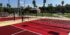 the photo shows several pickleball courts constructed by ferandell tennis courts at the saboba reservation in san jacinto, california using custom colors of maroon and bright red courts surrounded by a sandstone surround.