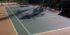 new construction of a dark green tennis court with a tan surround and white striping built by ferandell tennis courts