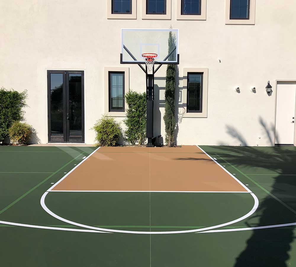 photo shows a half basketball court with a tan key area with all the other areas and surround painted in forest green.