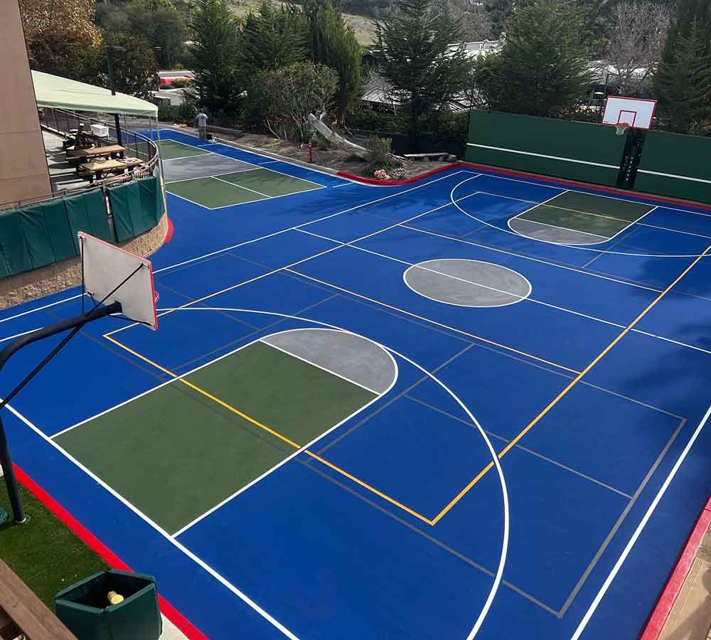 photo of a full size basketball court with additional striping for pickleball courts