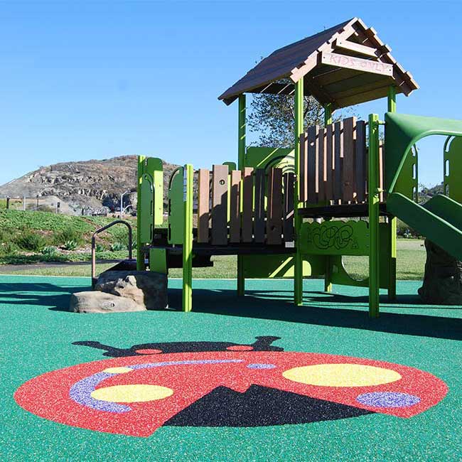 photo shows a beautiful green woodland children's jungle gym with a cushioned surface and ladybug design in it.
