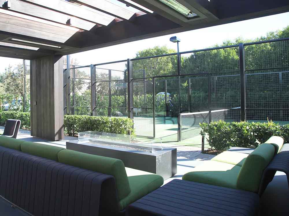 photo shows an amazing padel tennis court just off a beautiful covered patio.