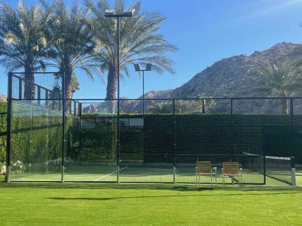 photo shows a padel tennis court surrounded by real grass.