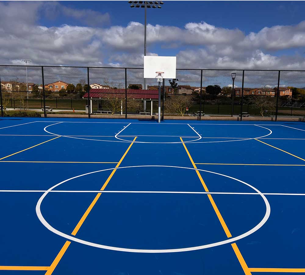 photo shows a royal blue sports court with striping for playing pickleball and basketball.