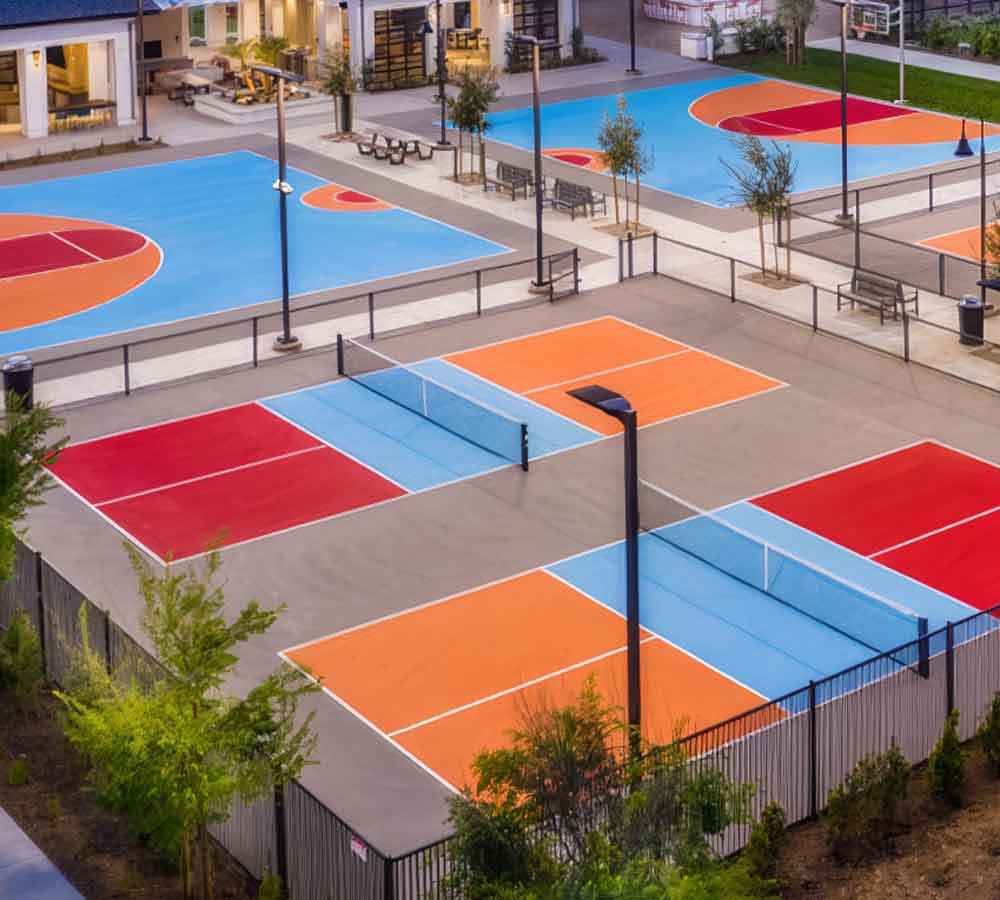 gorgeous candy-colored pickleball courts and basketball courts using light blue, red and bright orange.