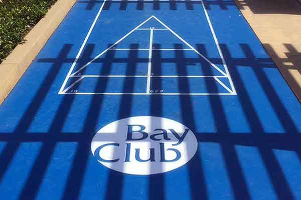 photo shows a bright blue shuffleboard with bay club logo.-1