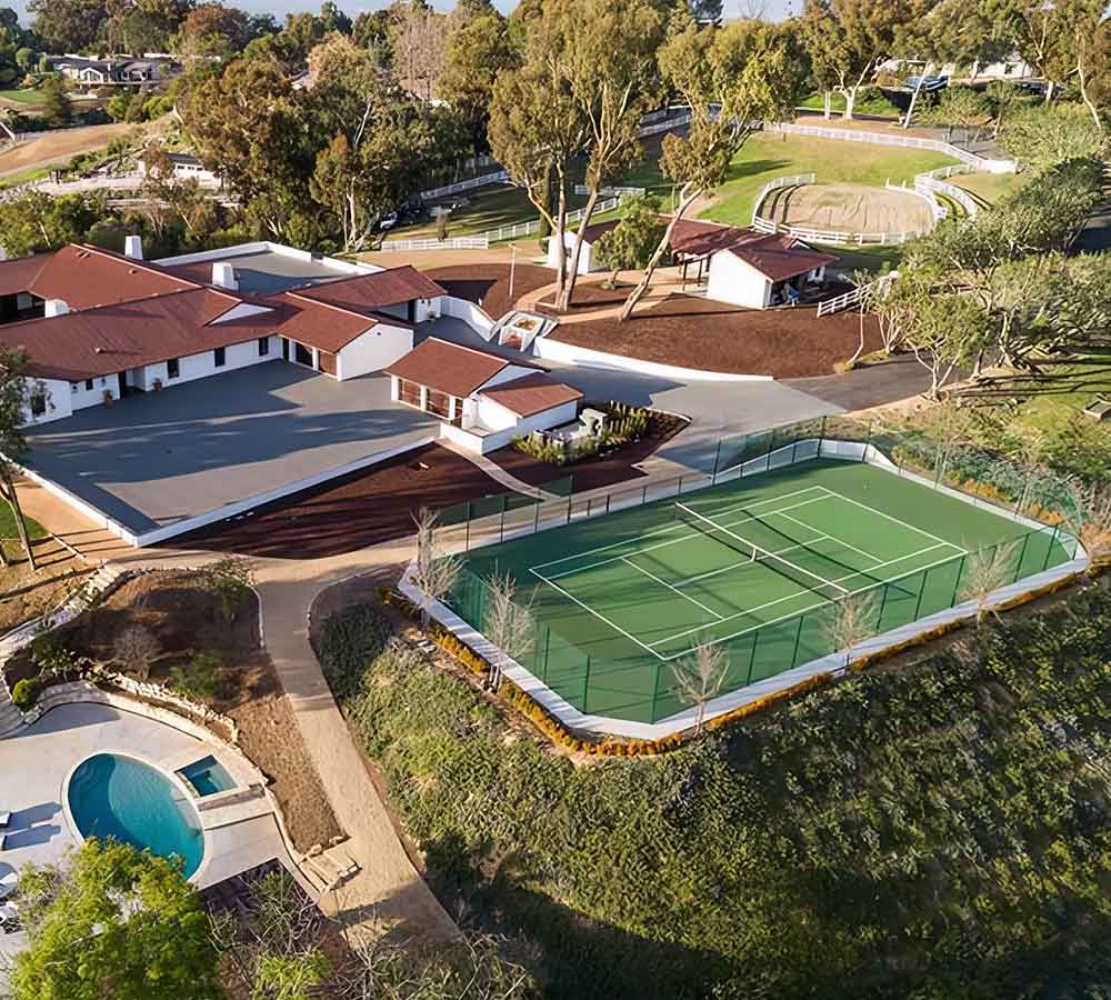 photo shows an aerial view of a luxury property with a tennis court built by Ferandell Tennis Courts